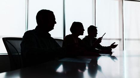 People sitting in a meeting in a boardroom.