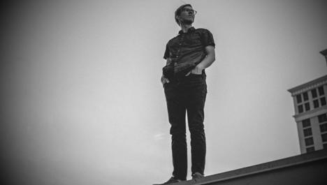 Man on a rooftop, looking back. A slightly adapted photo from Analise Benevides on Unsplash.