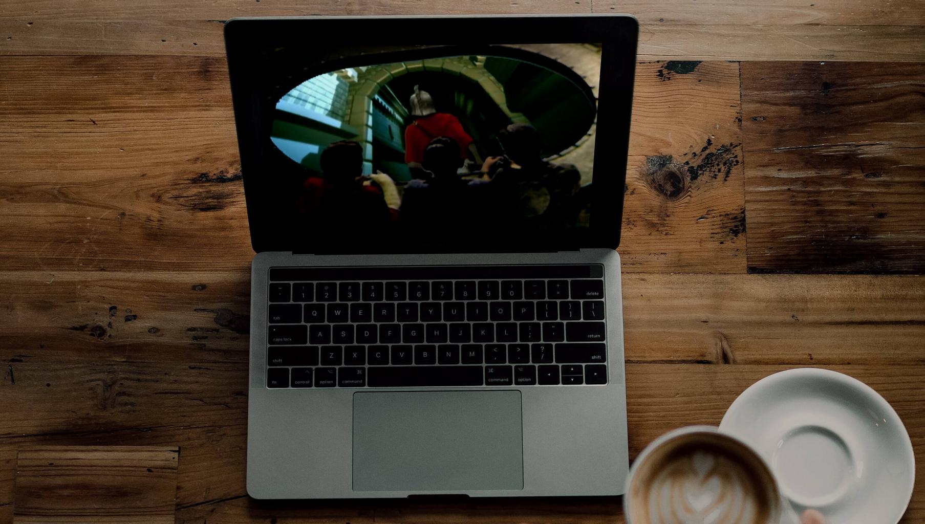 Watching Knightmare clips on a laptop with coffee. Adapted from photo by Nathan Ansell on Unsplash.