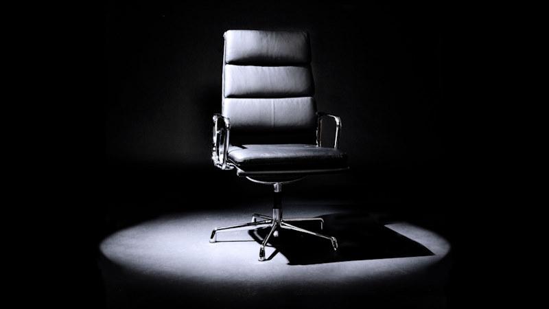 Black chair with leather padding in a spotlight