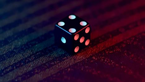 Dice on red textile. Photo by Joel Abraham on Unsplash.