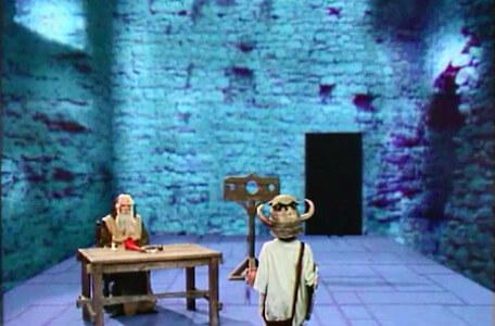 Knightmare Series 4 Quest 2. Merlin is sat at a table in Level 2.
