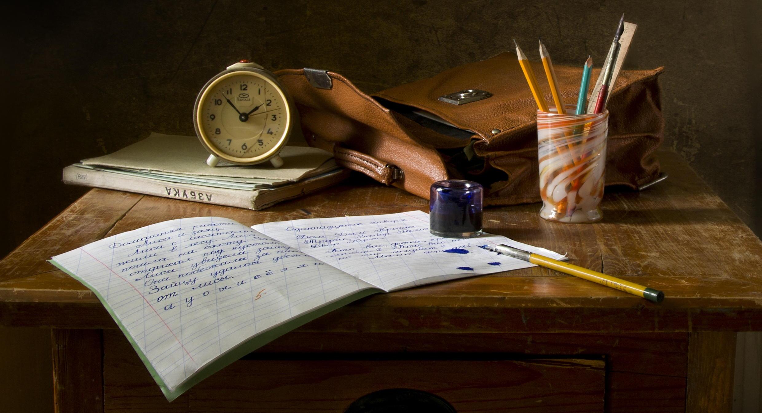 A desk with a pen, paper, and books